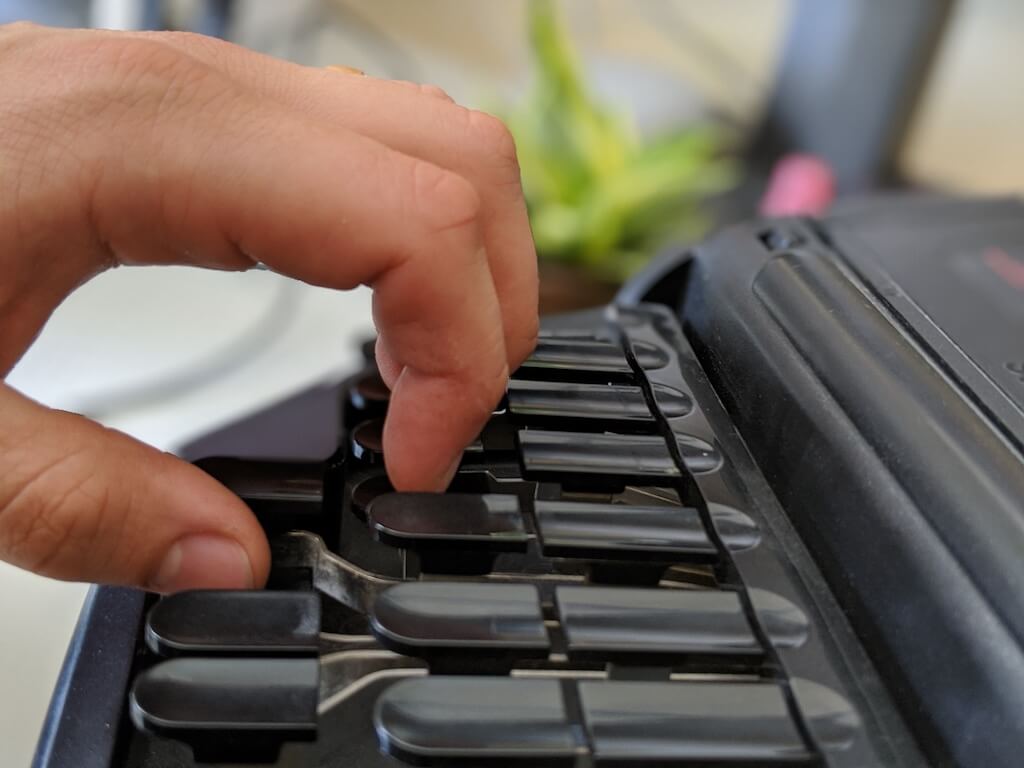 Stenographer hitting the top key by shifting their finger down then pressing down on the key