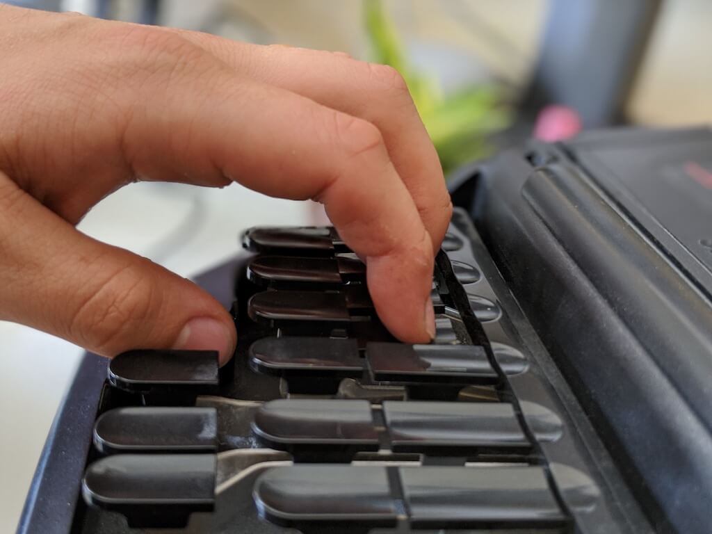 Stenographer hitting the top key by shifting their finger up then pressing down on the key